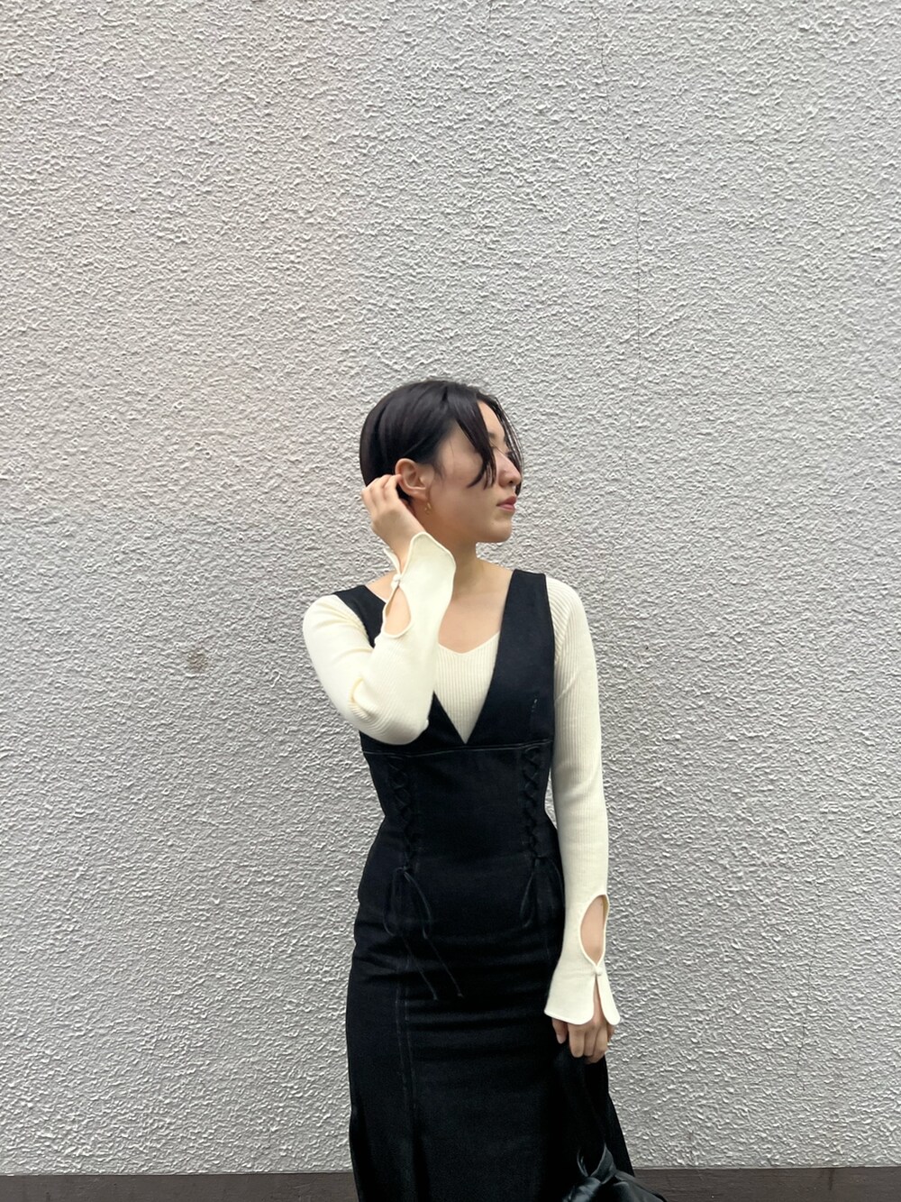 ブラック系のハンドバッグ、ブラック系のワンピース、ホワイト系のニット/セーターを着用したレディースの秋コーディネートの4枚目の写真