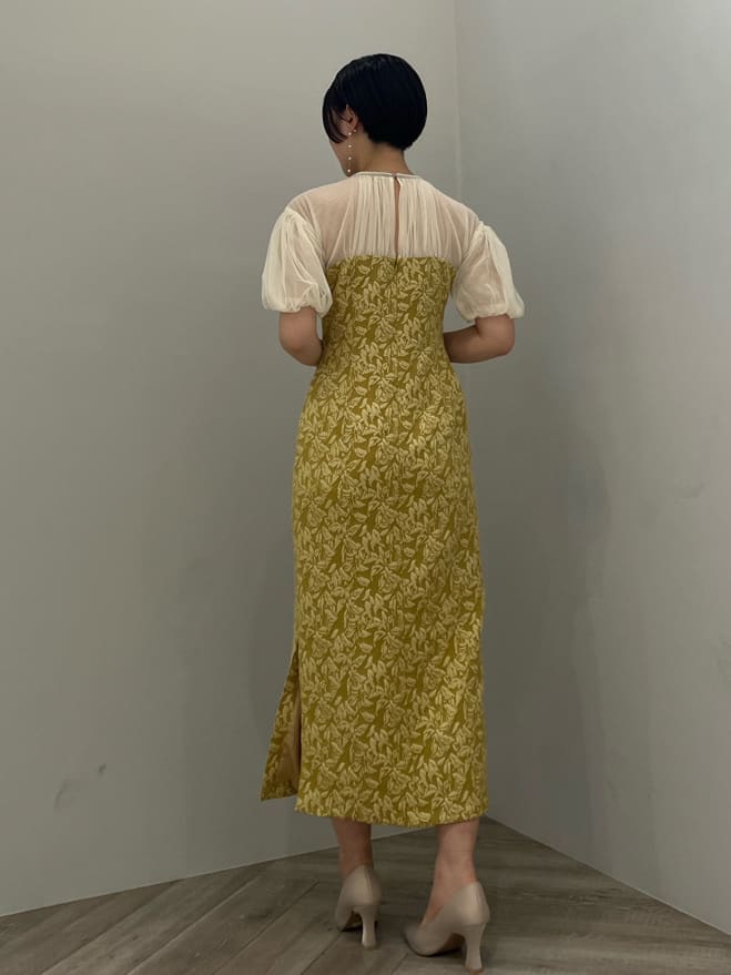 ベージュ系のパンプス、イエロー系のドレス、ベージュ系のクラッチバッグを着用したレディースの秋コーディネートの3枚目の写真