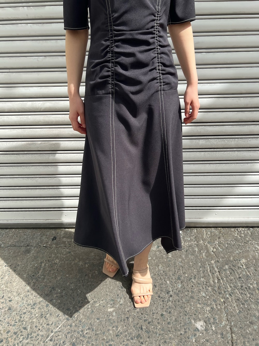 ベージュ系のサンダル、ブラック系のワンピース、ベージュ系のテーラードジャケットを着用したレディースの春コーディネートの7枚目の写真