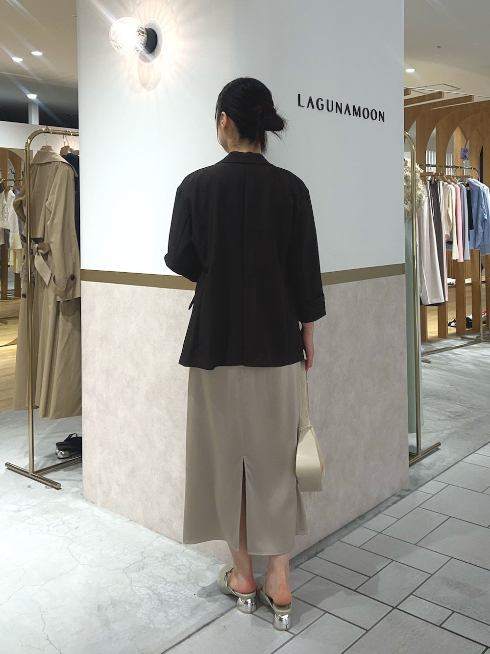 ベージュ系のワンピース、ブラウン系のテーラードジャケット、グリーン系のパンプスを着用したレディースの春コーディネートの2枚目の写真