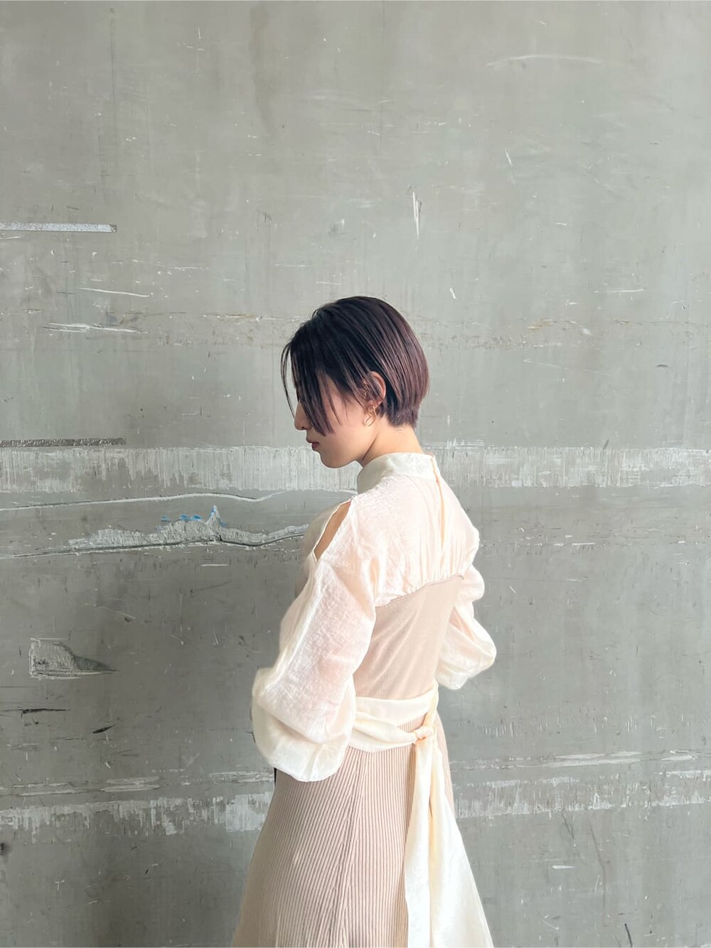 ホワイト系のトレンチコート、ベージュ系のワンピース、ベージュ系のハンドバッグを着用したレディースの春コーディネートの9枚目の写真