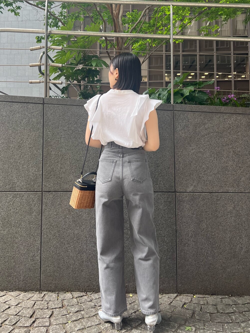 シルバー系のパンプス、グレー系のデニムパンツ、ホワイト系のシャツ/ブラウスを着用したレディースの春コーディネートの2枚目の写真