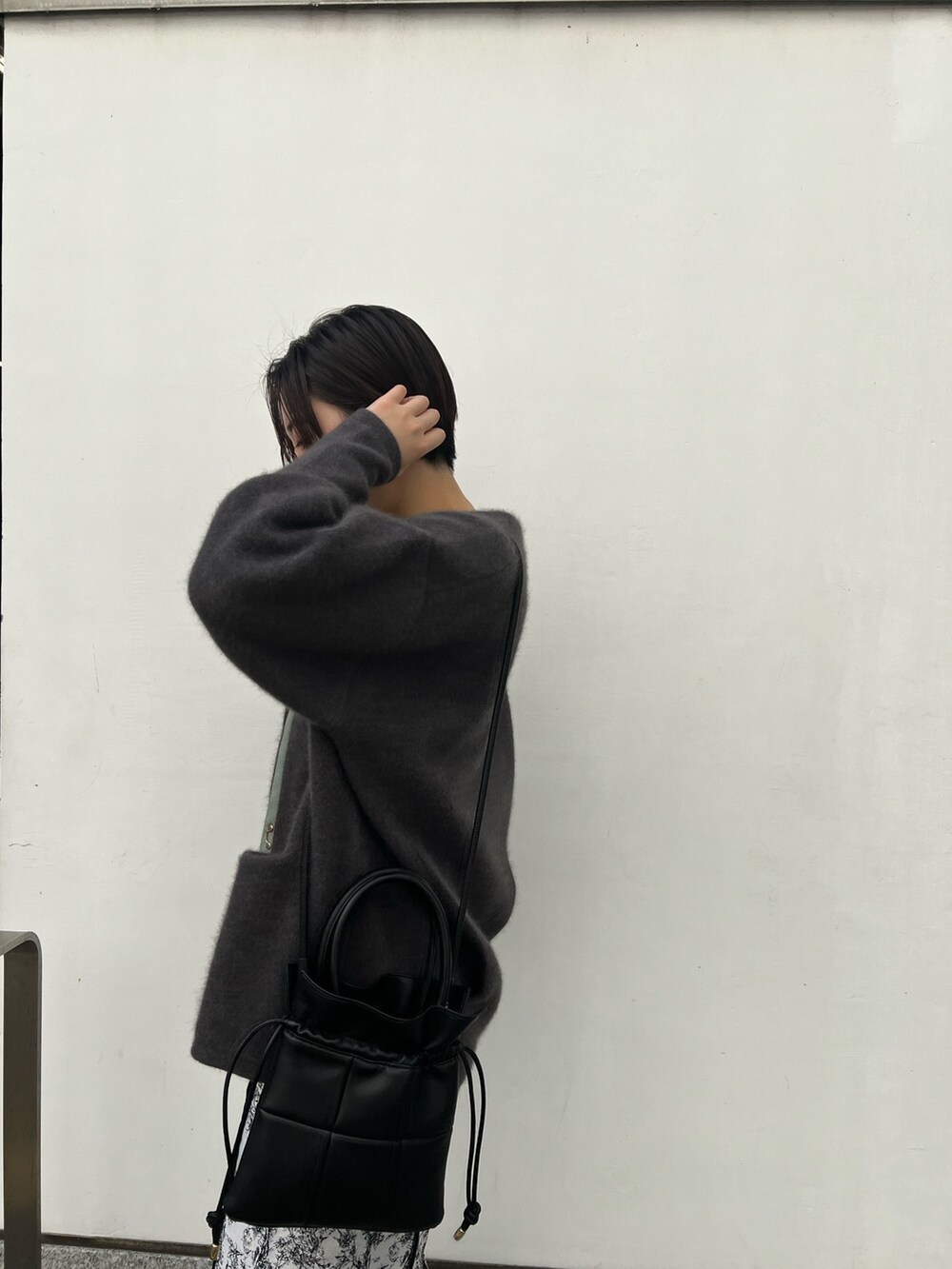 ブラック系のブーツ、ブラック系のスカート、グレー系のカーディガン/ボレロを着用したレディースの秋コーディネートの3枚目の写真