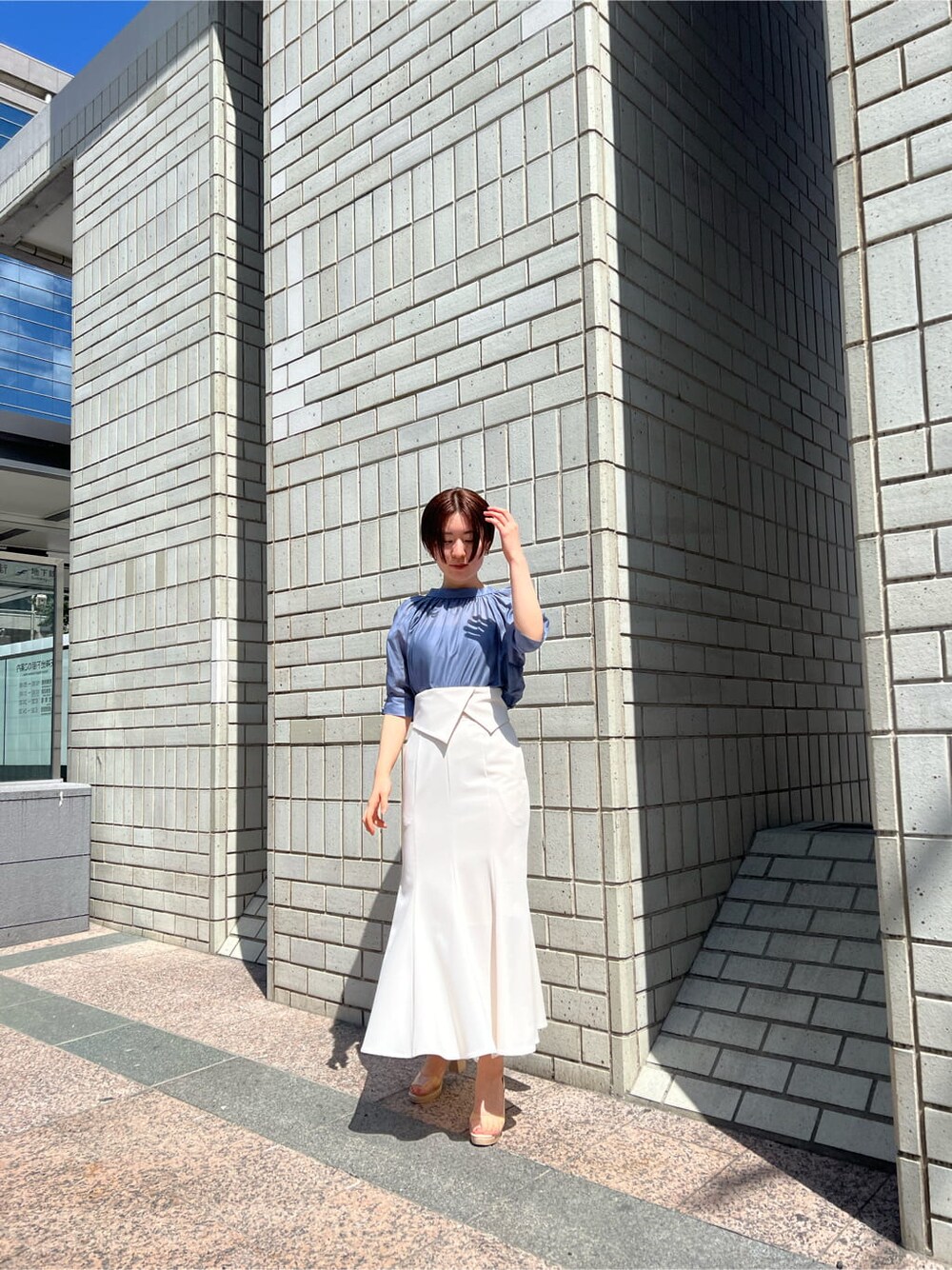 ホワイト系のスカート、その他のパンプス、ブルー系のシャツ/ブラウスを着用したレディースの春コーディネートの2枚目の写真