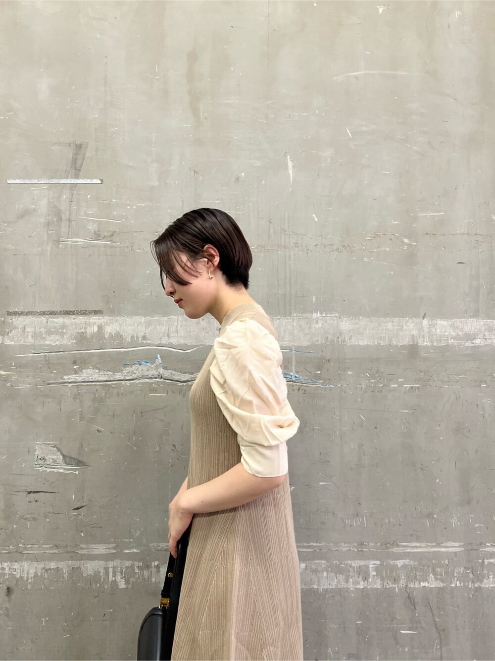 ベージュ系のワンピース、ベージュ系のブーツ、ブラック系のショルダーバッグを着用したレディースの夏コーディネートの5枚目の写真