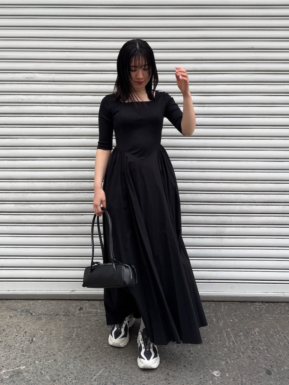 ブラック系のワンピース、ブルー系のテーラードジャケット、グレー系のスニーカーを着用したレディースの冬コーディネートの5枚目の写真