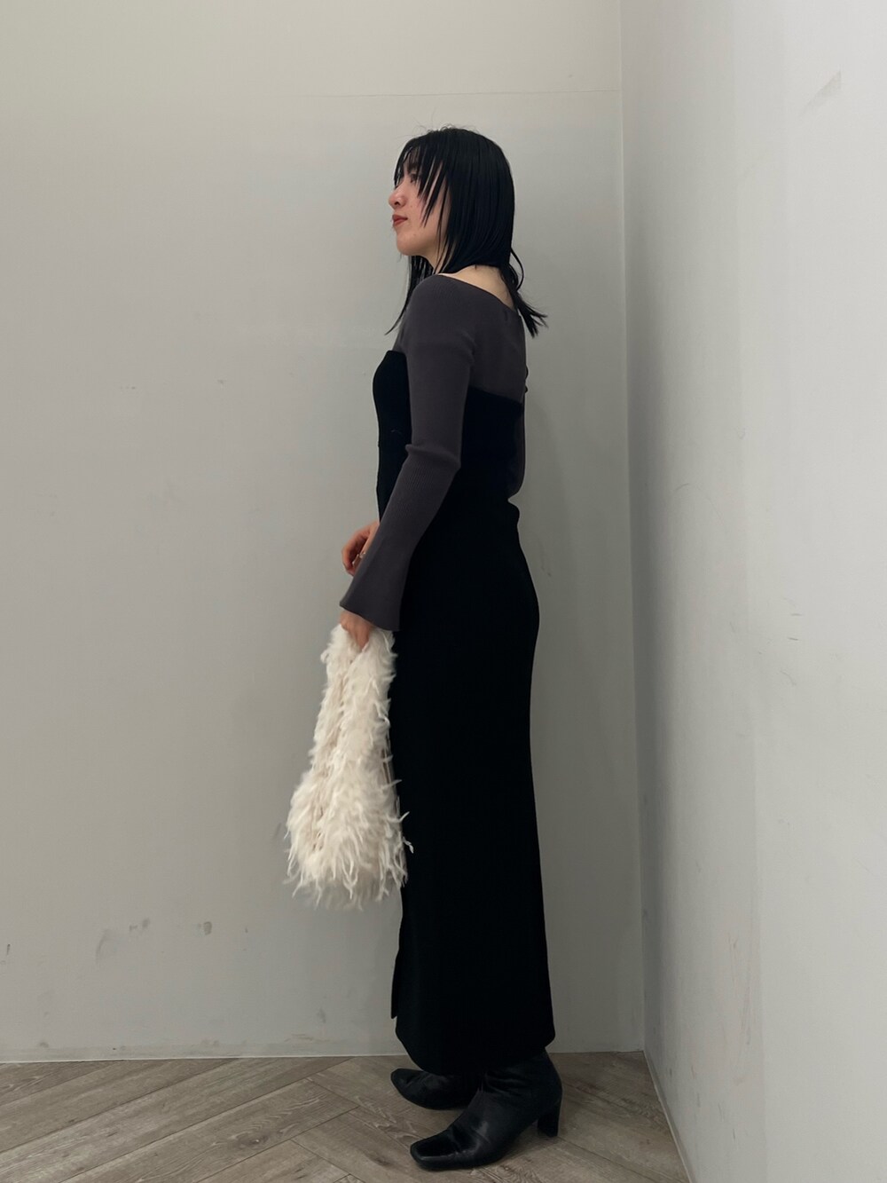 グレー系のニット/セーター、ブラック系のワンピースを着用したレディースの冬コーディネートの2枚目の写真