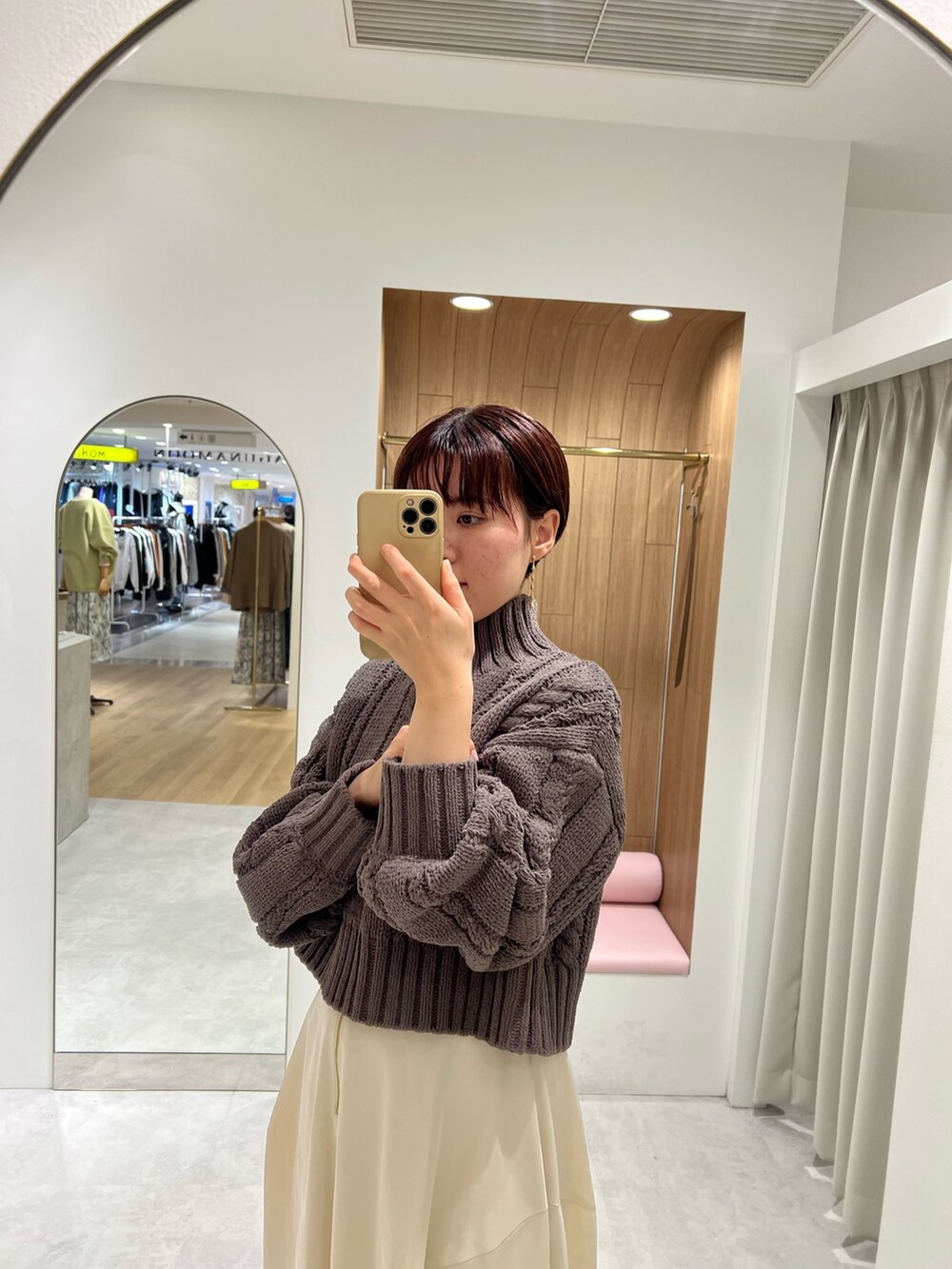 ホワイト系のスカート、グレー系のニット/セーター、ベージュ系のブーツを着用したレディースの秋コーディネートの2枚目の写真