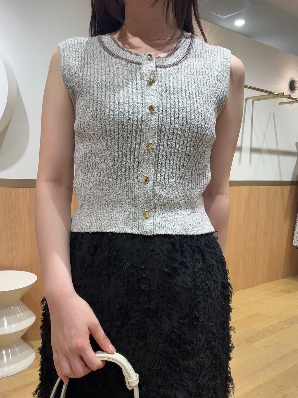ブラック系のスカート、ベージュ系のニット/セーター、ベージュ系のサンダルを着用したレディースの春コーディネートの3枚目の写真