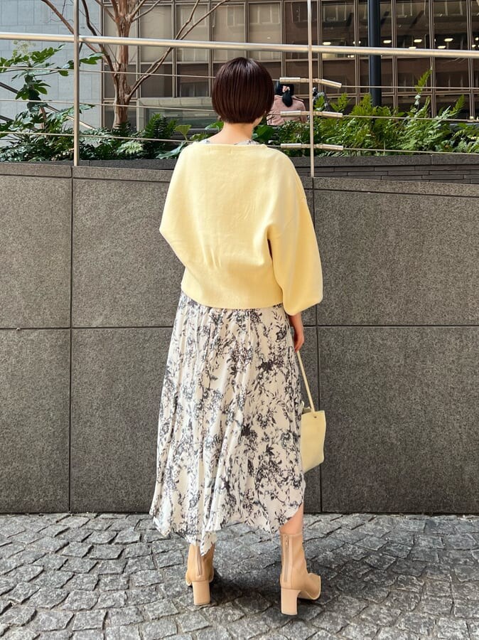 ベージュ系のブーツ、ホワイト系のハンドバッグ、イエロー系のカーディガン/ボレロを着用したレディースの春コーディネートの3枚目の写真