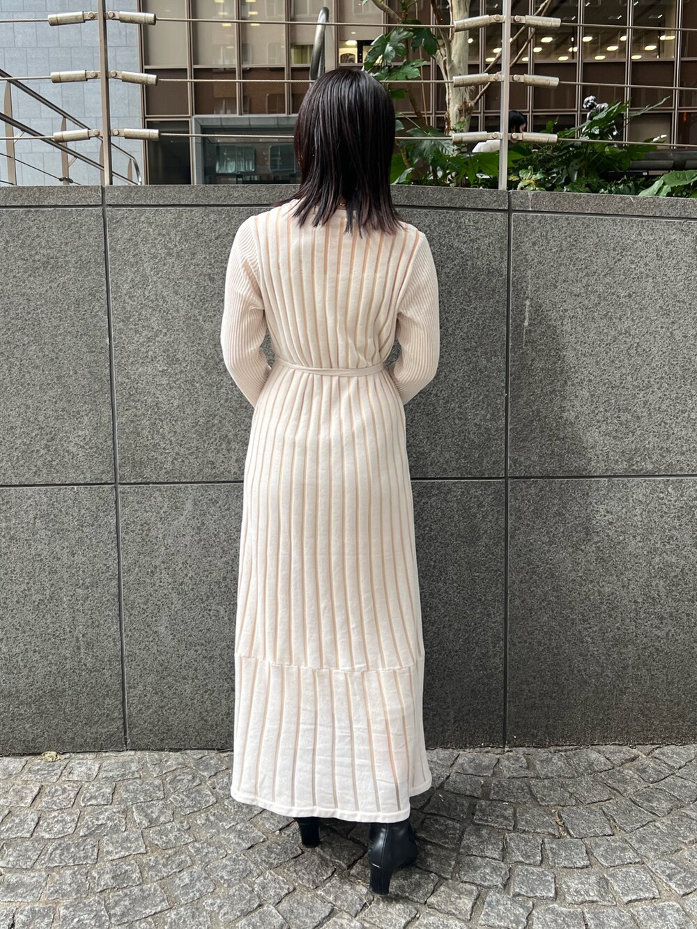 ブラック系のブーツ、ホワイト系のカーディガン/ボレロ、ホワイト系のショルダーバッグを着用したレディースの秋コーディネートの4枚目の写真