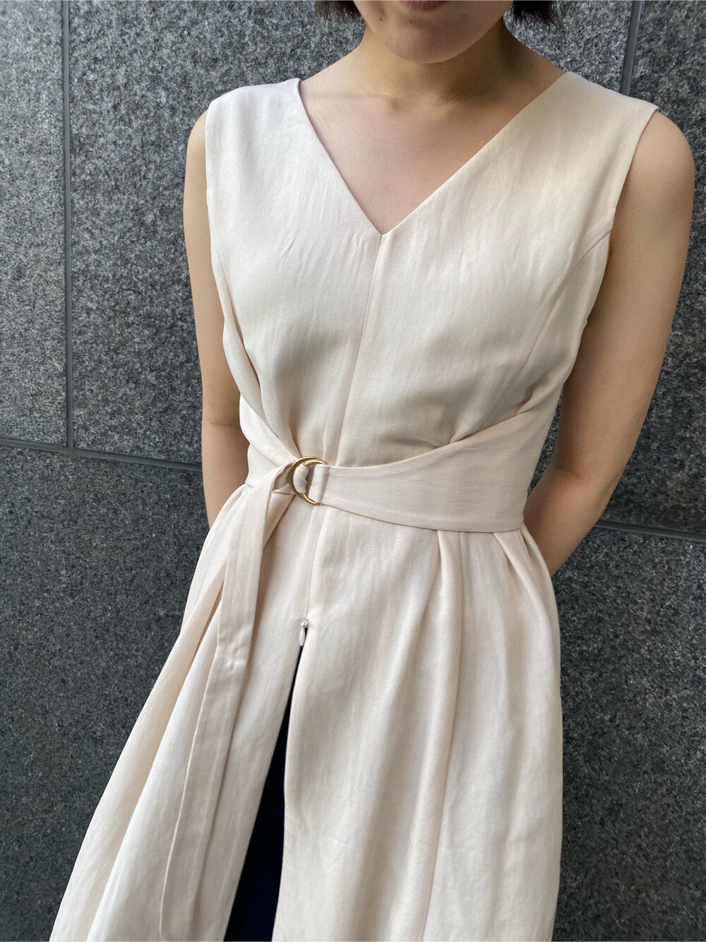 ブルー系のデニムパンツ、ブラウン系のサンダル、ベージュ系のワンピースを着用したレディースの春コーディネートの4枚目の写真