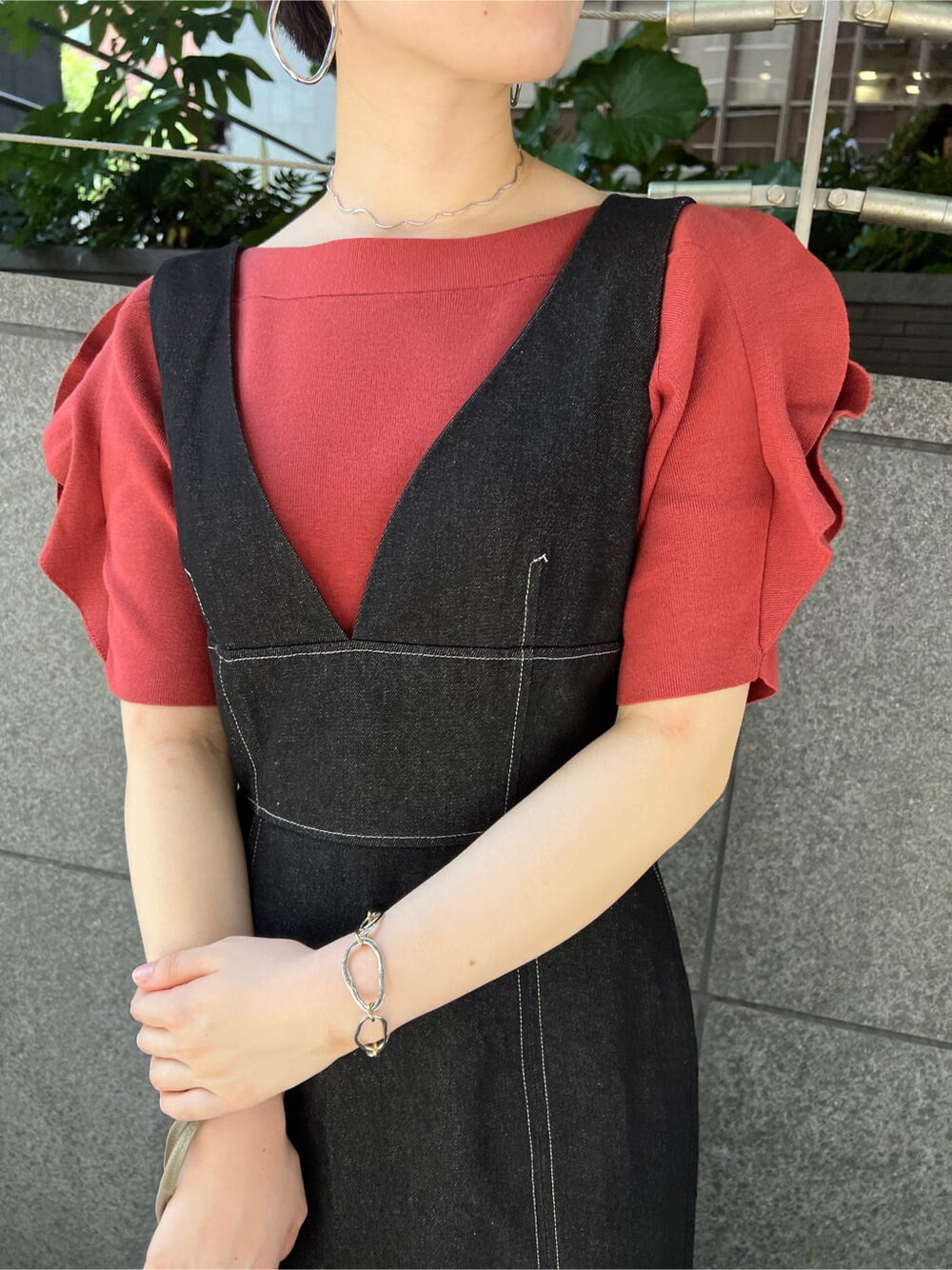 ベージュ系のハンドバッグ、ブラック系のワンピース、オレンジ系のニット/セーターを着用したレディースの夏コーディネートの5枚目の写真