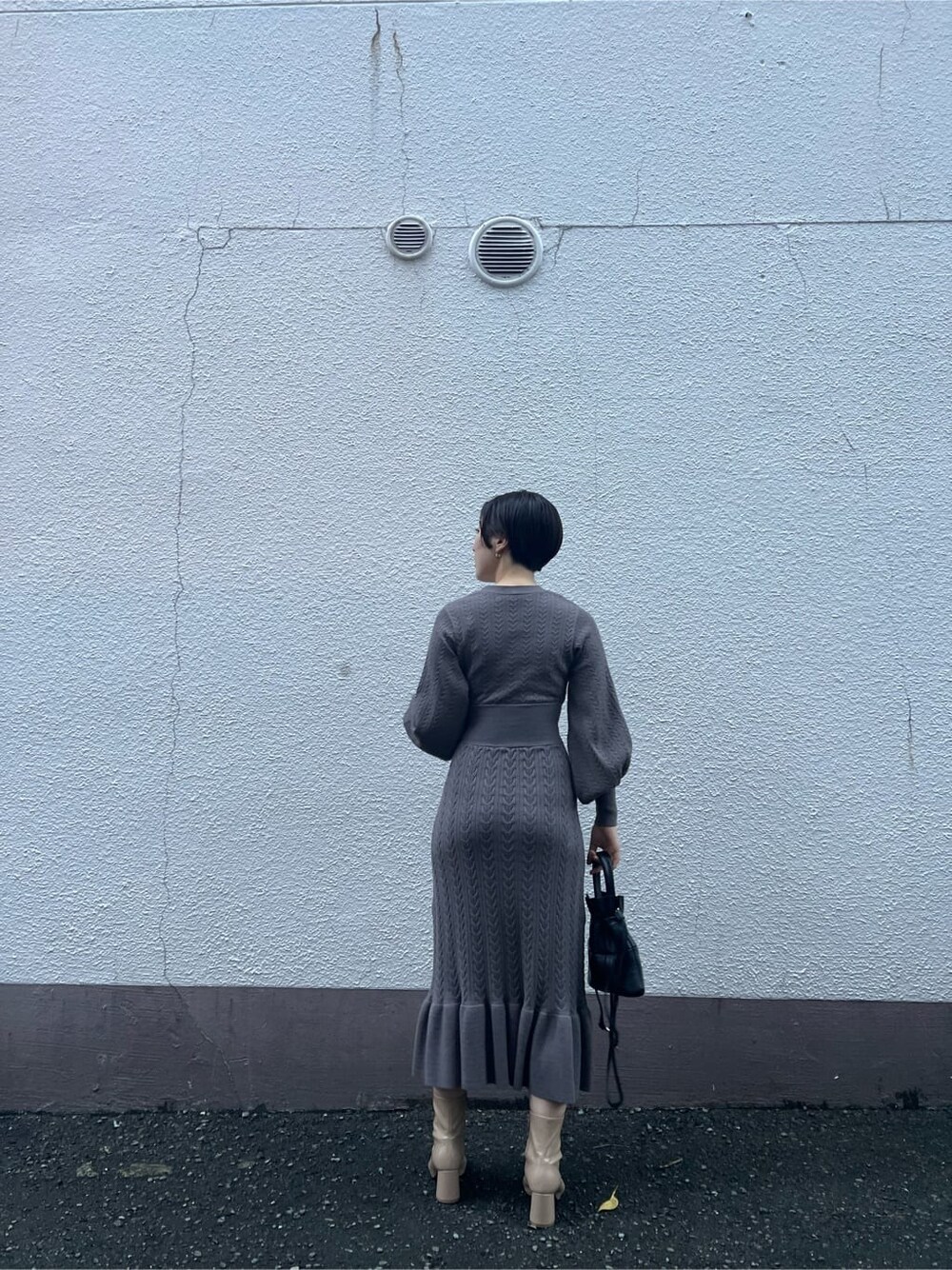 ブラウン系のワンピース、ベージュ系のブーツ、ブラック系のハンドバッグを着用したレディースの秋コーディネートの7枚目の写真