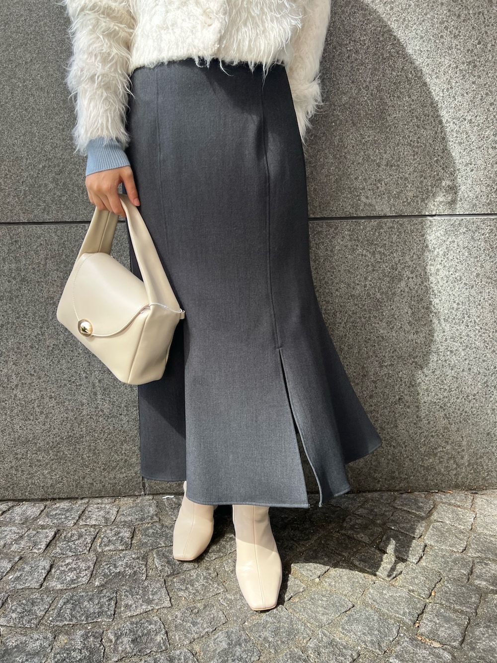 ホワイト系のブーツ、ホワイト系のカーディガン/ボレロ、ブルー系のニット/セーターを着用したレディースの秋コーディネートの5枚目の写真