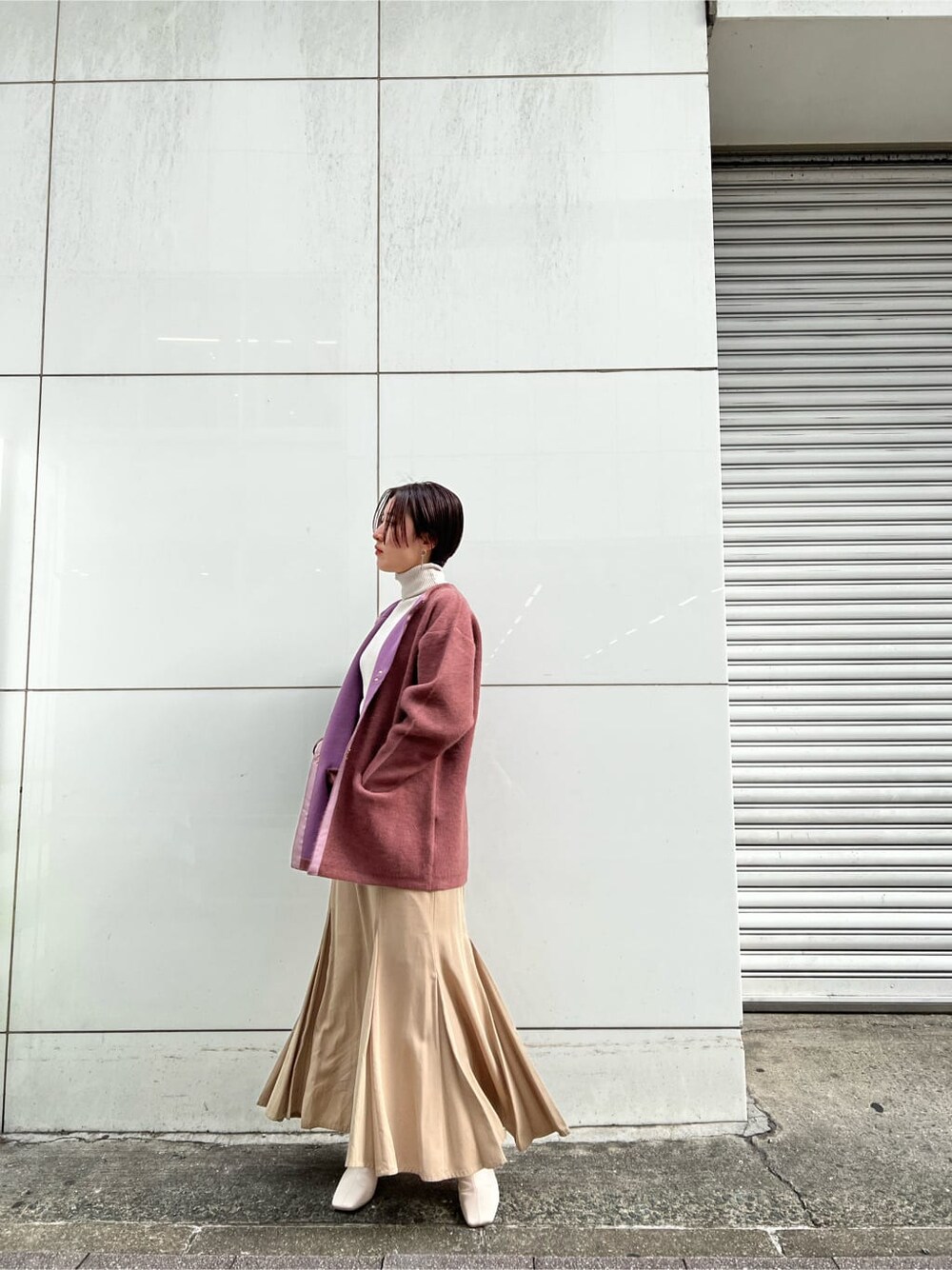 ベージュ系のスカート、ホワイト系のその他シューズ、ピンク系のカーディガン/ボレロを着用したレディースの冬コーディネートの2枚目の写真