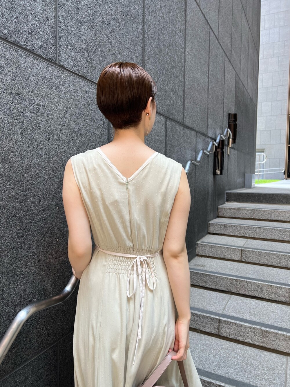 ベージュ系のサンダル、ホワイト系のハンドバッグ、グリーン系のワンピースを着用したレディースの夏コーディネートの5枚目の写真