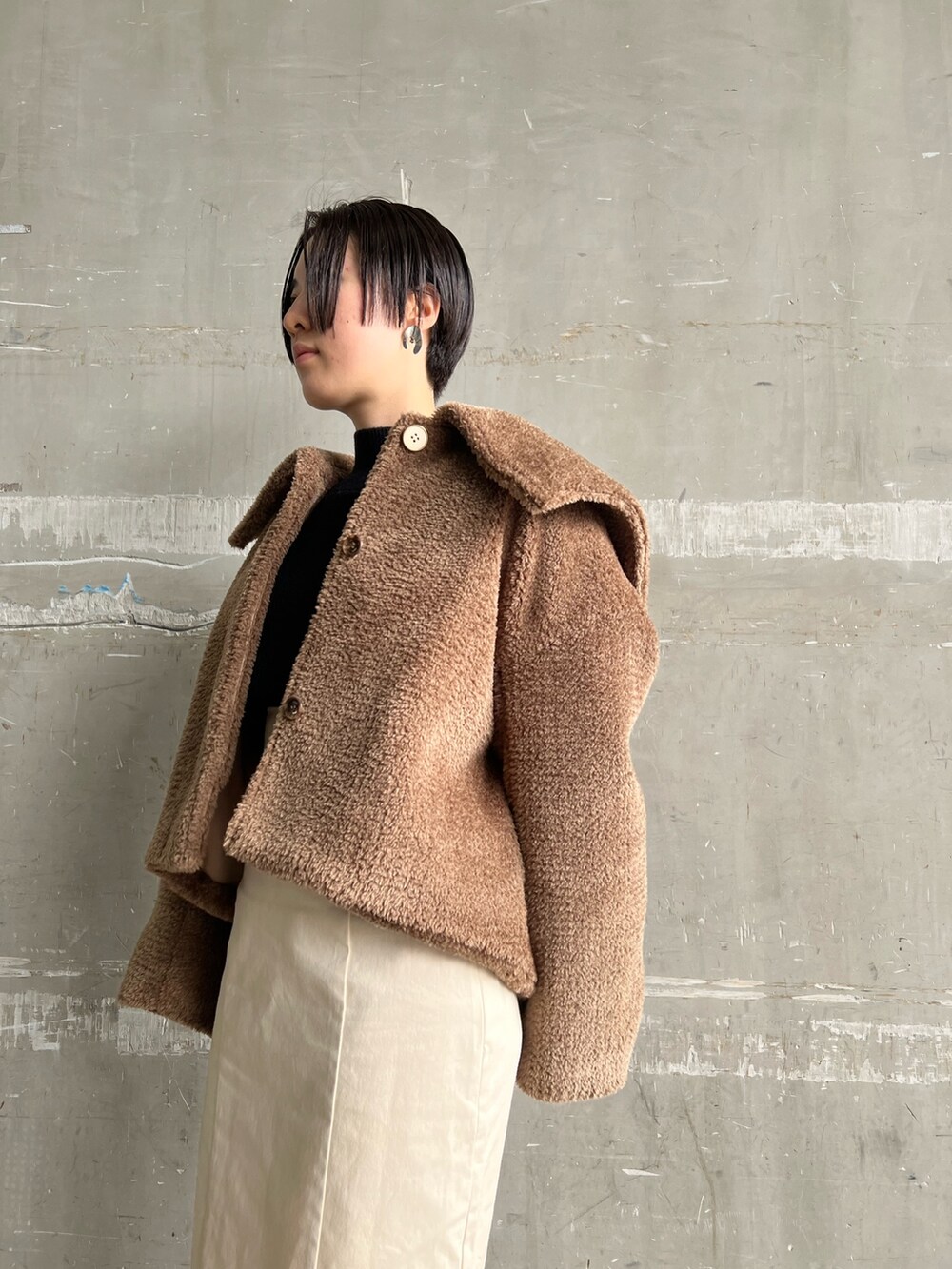 レッド系のブーツ、ホワイト系のスカート、ブラウン系のブルゾンを着用したレディースの冬コーディネートの9枚目の写真