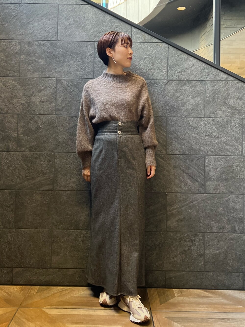 ベージュ系のスニーカー、ブラウン系のスカート、ベージュ系のダウンジャケット/コートを着用したレディースの秋コーディネートの7枚目の写真