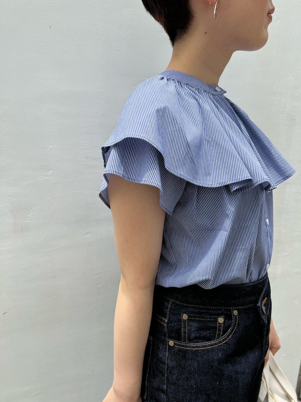 ベージュ系のサンダル、ホワイト系のショルダーバッグ、ブルー系のデニムパンツを着用したレディースの夏コーディネートの4枚目の写真