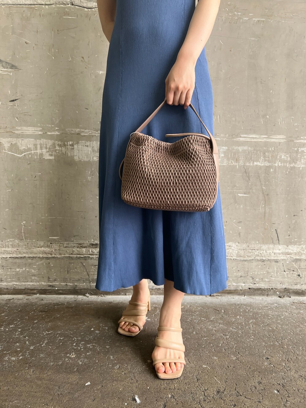 ホワイト系のハンドバッグ、ブルー系のワンピース、ベージュ系のサンダルを着用したレディースの夏コーディネートの6枚目の写真