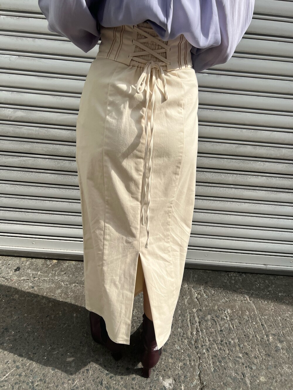 レッド系のブーツ、ホワイト系のスカート、ホワイト系のカーディガン/ボレロを着用したレディースの冬コーディネートの8枚目の写真