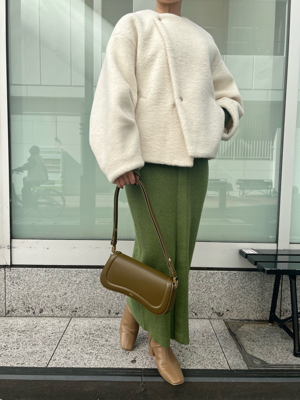 ブラウン系のショルダーバッグ、ベージュ系のブーツ、グリーン系のワンピースを着用したレディースの秋コーディネートの7枚目の写真