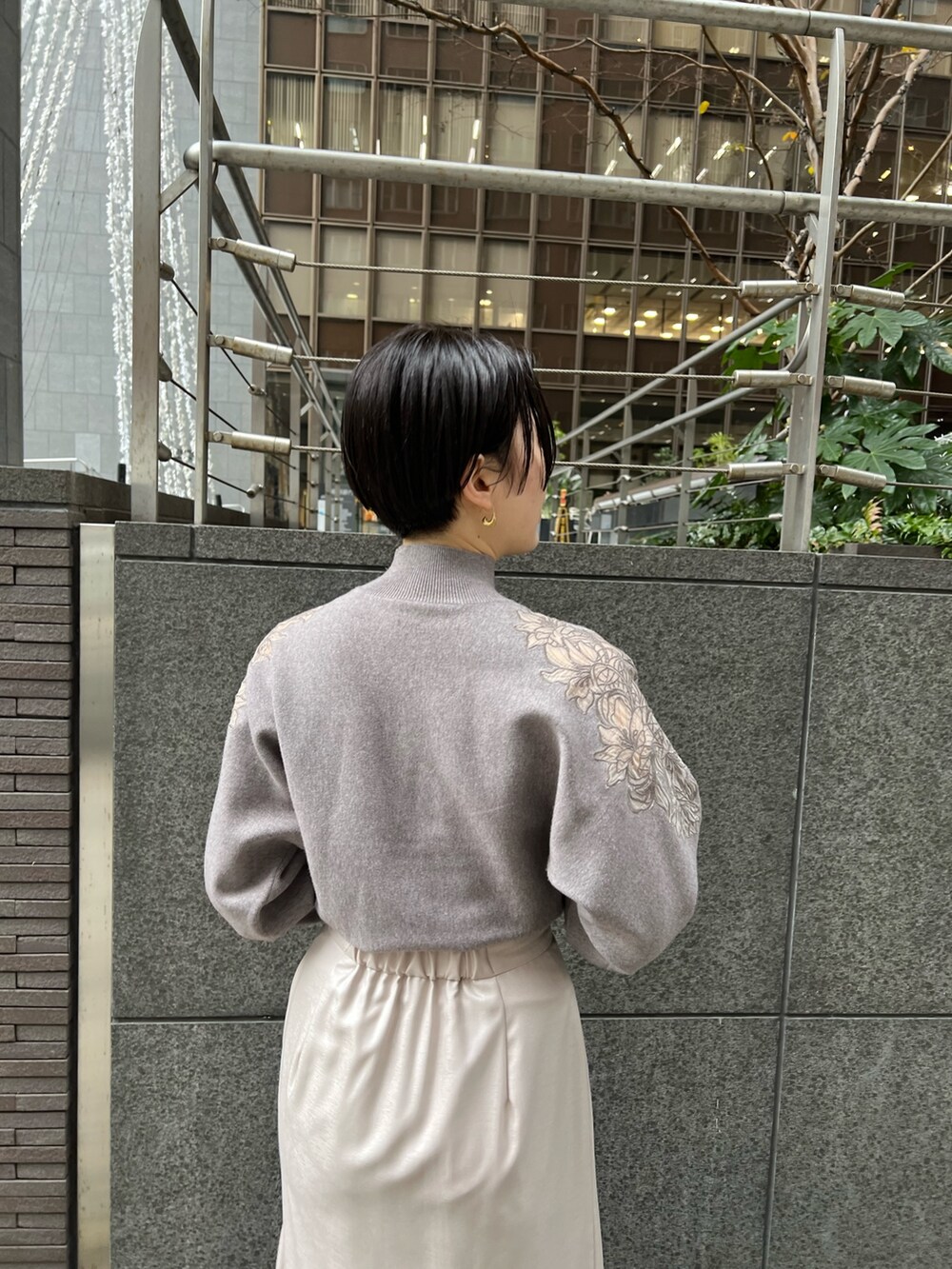 レッド系のブーツ、グレー系のスカート、グレー系のニット/セーターを着用したレディースの冬コーディネートの6枚目の写真