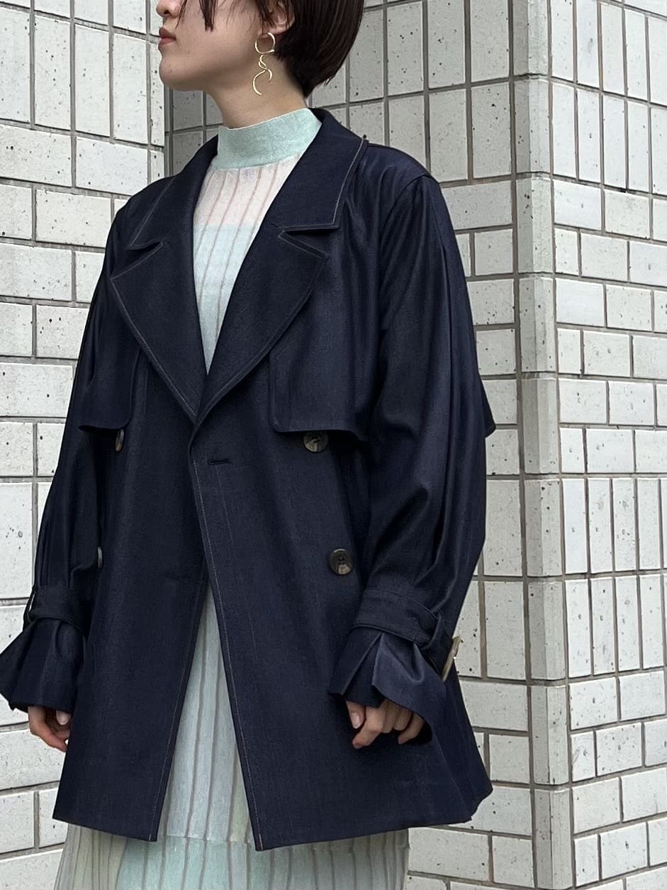 ベージュ系のブーツ、ブルー系のトレンチコート、グリーン系のワンピースを着用したレディースの春コーディネートの5枚目の写真