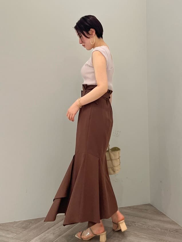 グリーン系のサンダル、ホワイト系のショルダーバッグ、ブラウン系のスカートを着用したレディースの春コーディネートの2枚目の写真