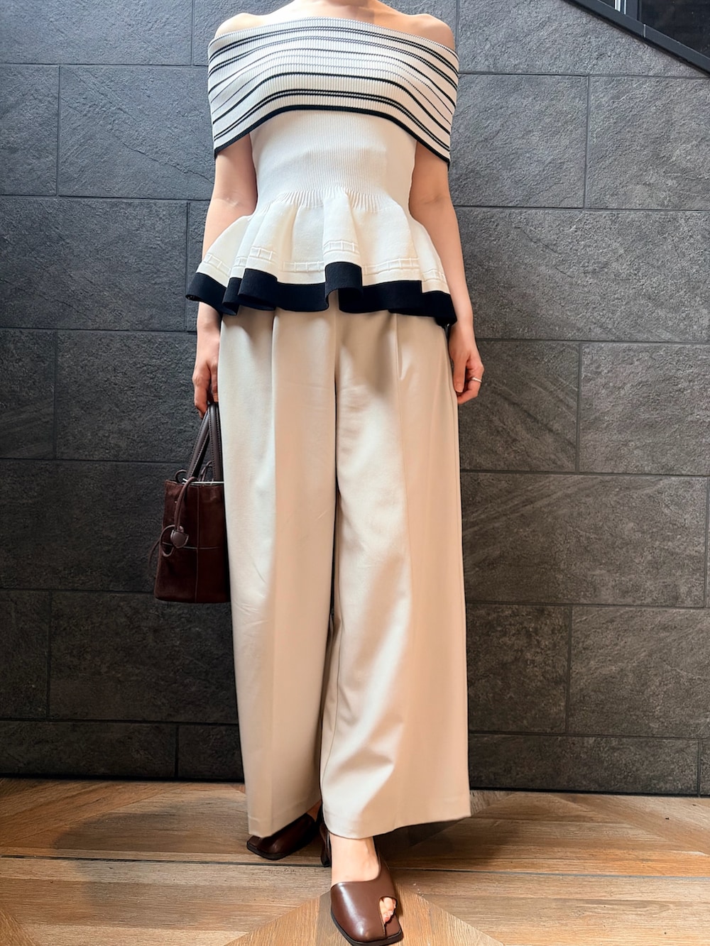 ホワイト系のニット/セーター、ホワイト系のその他パンツ、ブラック系のサンダルを着用したレディースの夏コーディネートの7枚目の写真