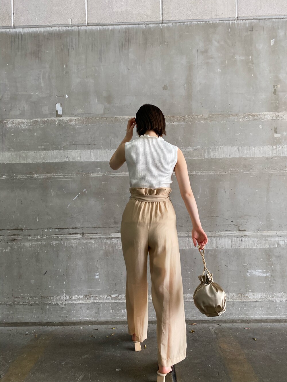 その他のその他シューズ、ベージュ系のその他パンツ、ゴールド系のハンドバッグを着用したレディースの春コーディネートの5枚目の写真