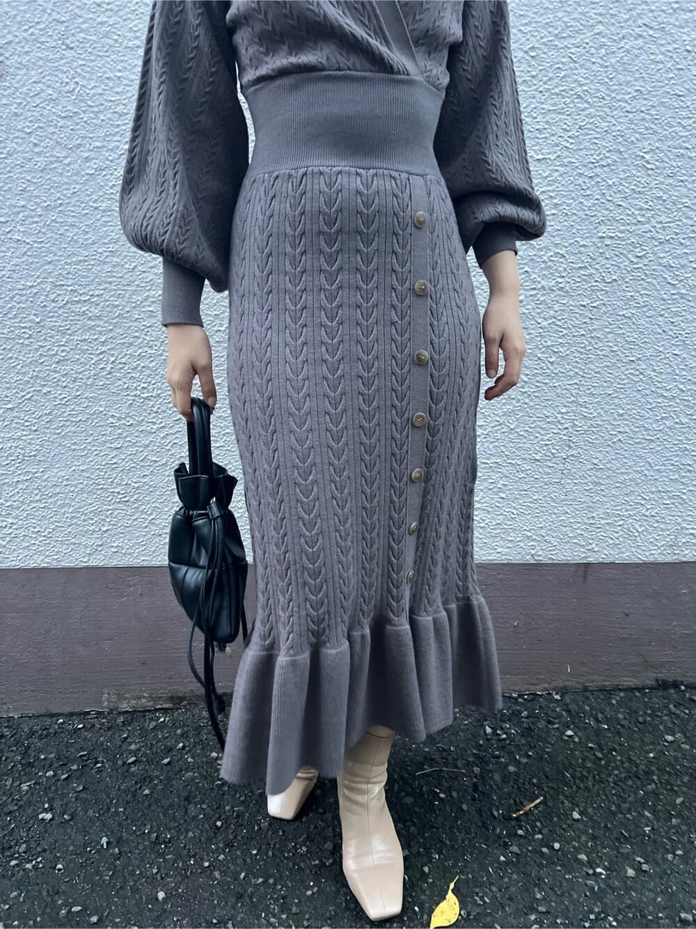 ブラウン系のワンピース、ベージュ系のブーツ、ブラック系のハンドバッグを着用したレディースの秋コーディネートの10枚目の写真