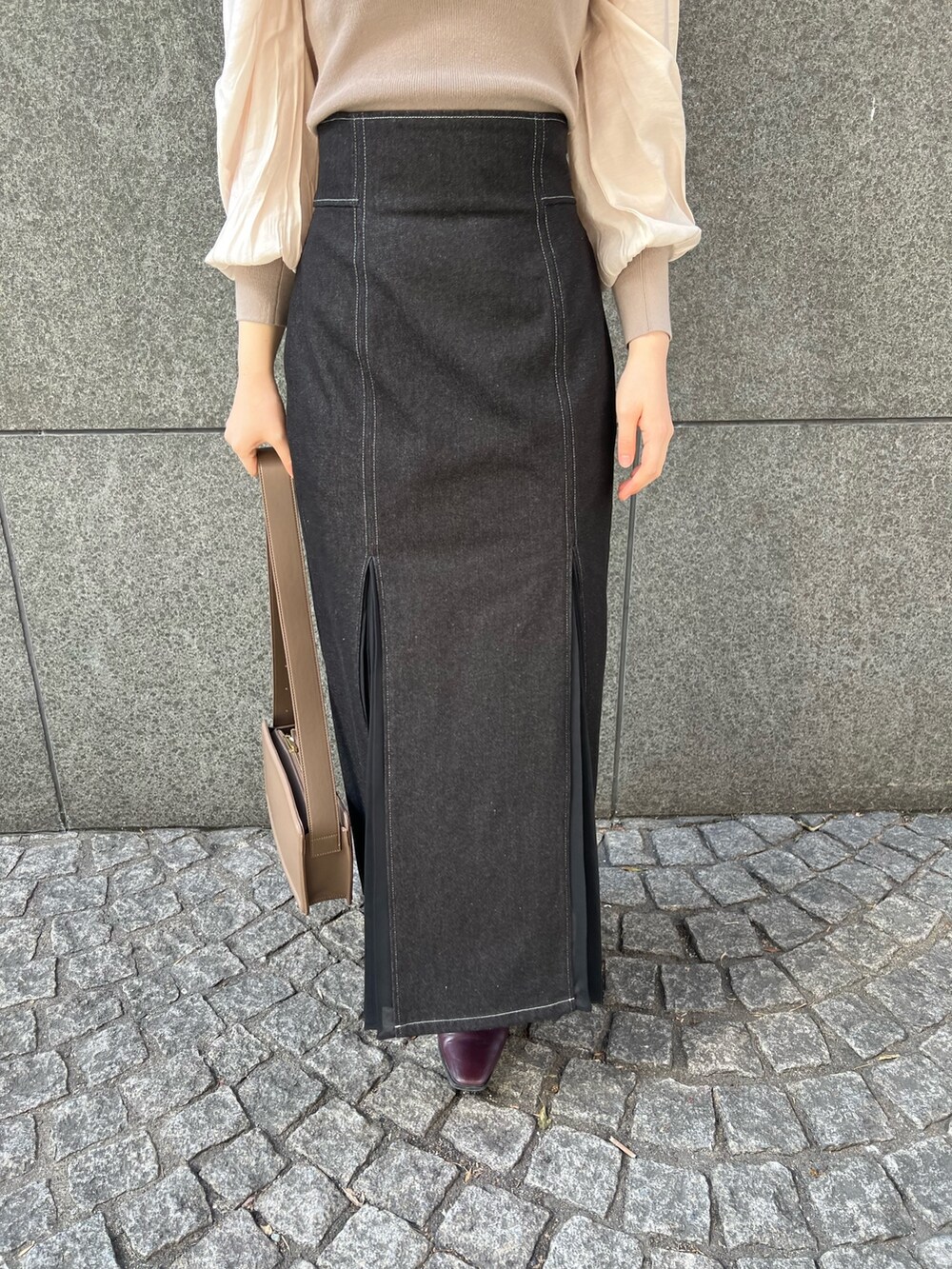 ブラック系のデニムスカート、ベージュ系のショルダーバッグ、レッド系のブーツを着用したレディースの冬コーディネートの9枚目の写真