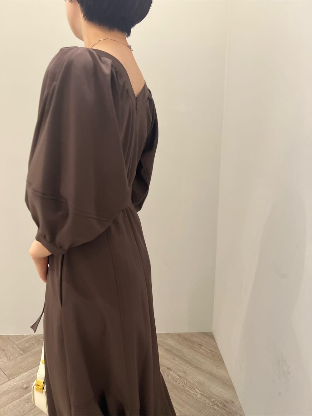 ホワイト系のサンダル、ブラウン系のワンピース、ホワイト系のショルダーバッグを着用したレディースの夏コーディネートの5枚目の写真