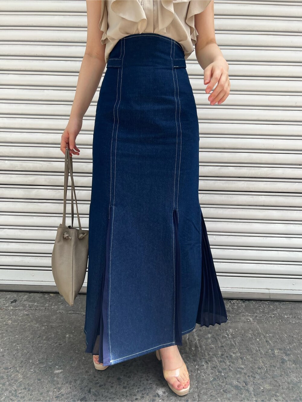 ベージュ系のハンドバッグ、ブルー系のスカート、その他のパンプスを着用したレディースの春コーディネートの7枚目の写真
