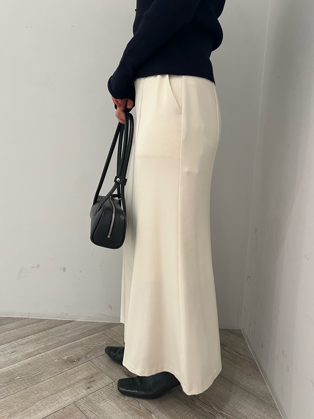 ブルー系のアンサンブル、ホワイト系のスカートを着用したレディースの冬コーディネートの6枚目の写真