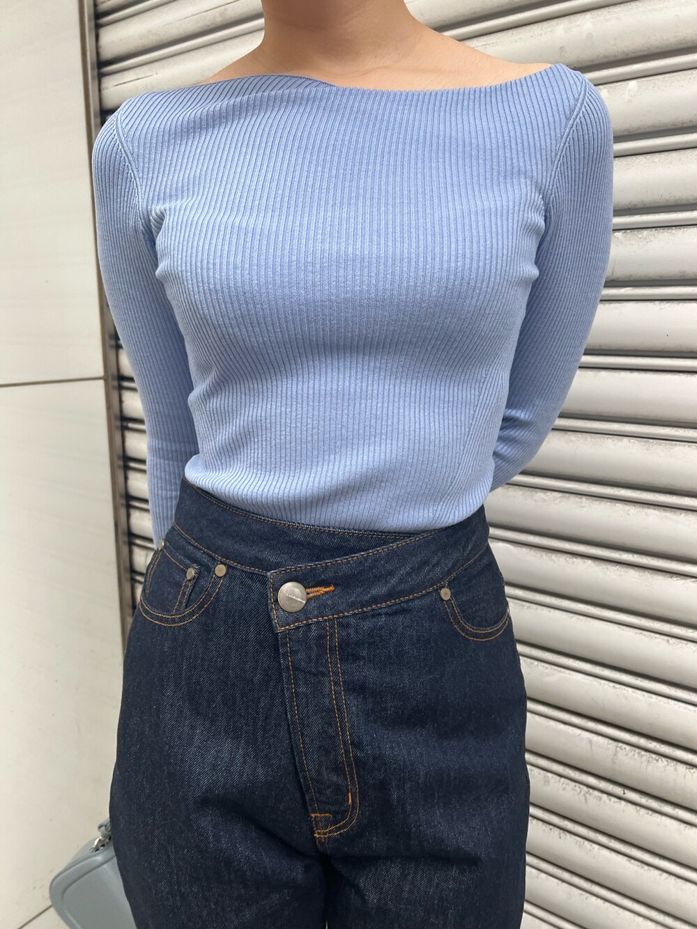 ブルー系のショルダーバッグ、ブルー系のニット/セーター、ベージュ系のブーツを着用したレディースの冬コーディネートの6枚目の写真