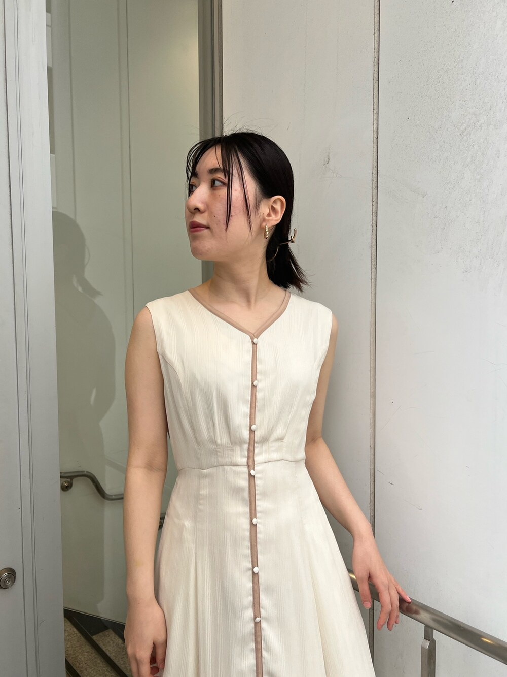 ブラック系のサンダル、ホワイト系のワンピースを着用したレディースの夏コーディネートの3枚目の写真