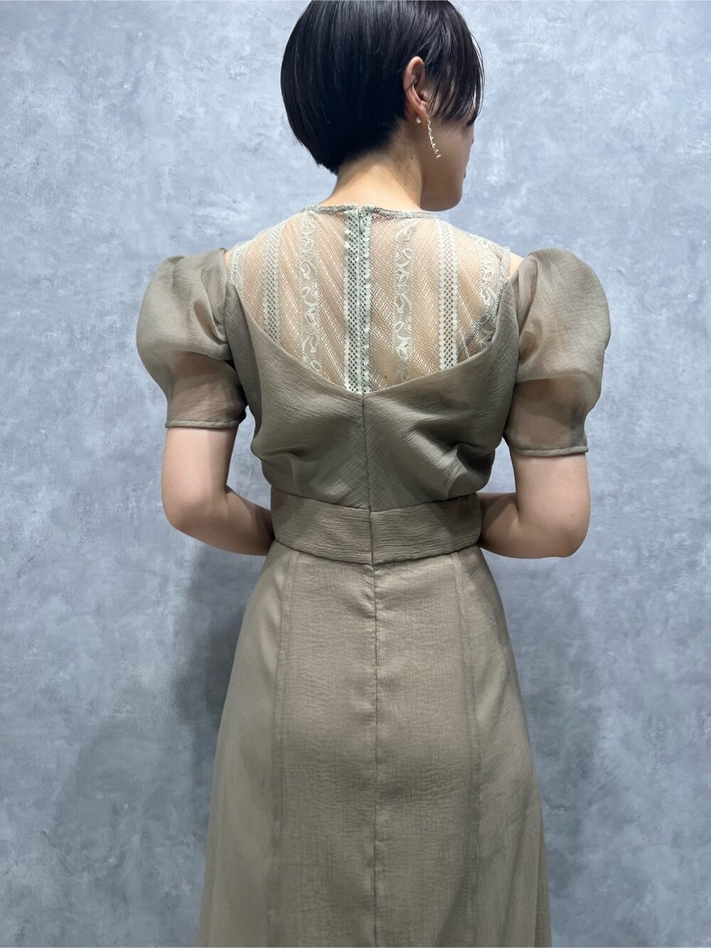 ベージュ系のドレス、ベージュ系のドレス、ゴールド系のパンプスを着用したレディースの秋コーディネートの6枚目の写真