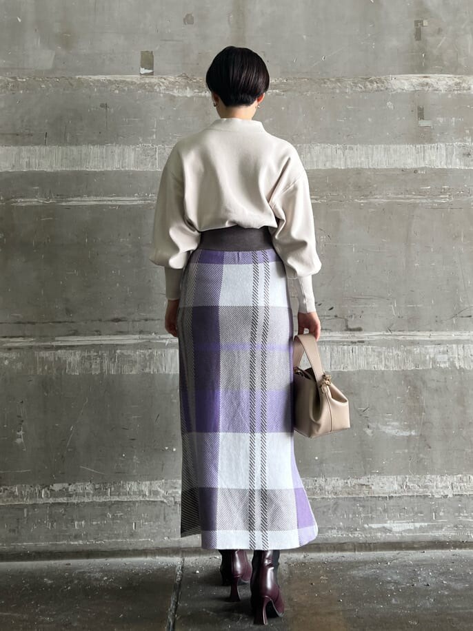 ホワイト系のニット/セーター、レッド系のブーツ、パープル系のスカートを着用したレディースの秋コーディネートの3枚目の写真