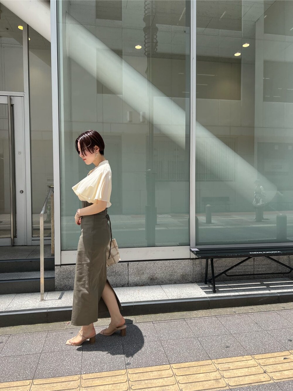 グリーン系のサンダル、ベージュ系のスカート、ホワイト系のショルダーバッグを着用したレディースの夏コーディネートの3枚目の写真