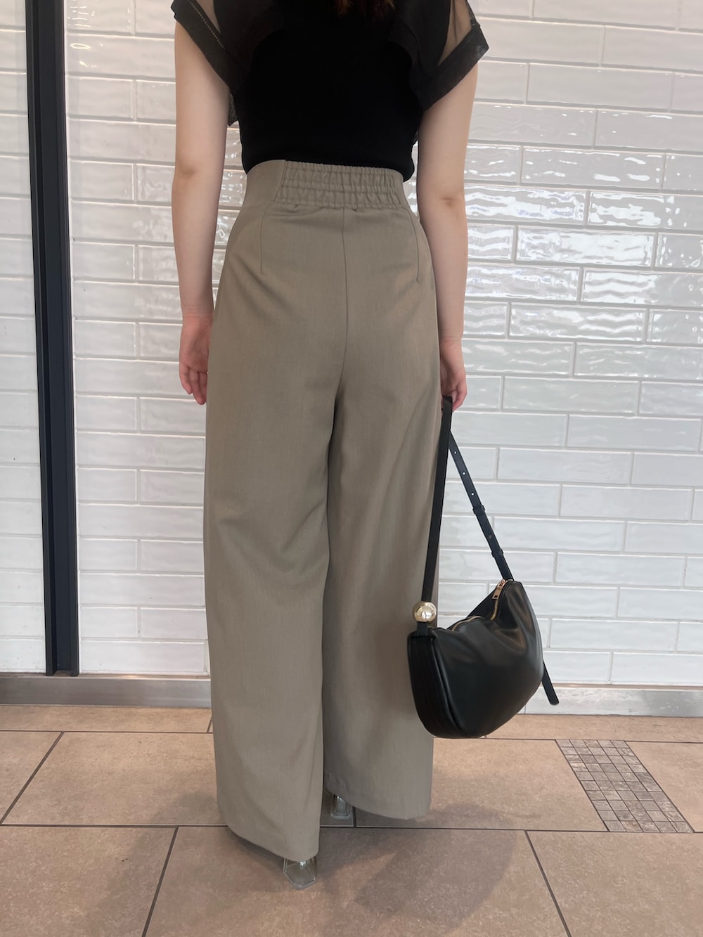 ブラウン系のその他パンツ、ブラック系のニット/セーター、ブラック系のサンダルを着用したレディースの春コーディネートの8枚目の写真