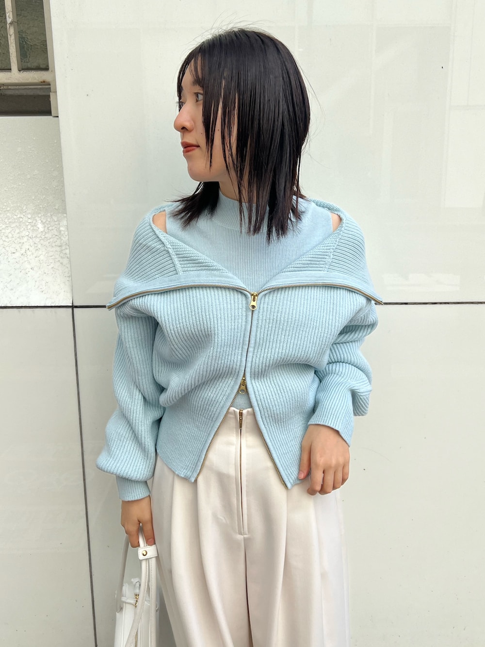 ホワイト系のショルダーバッグ、ホワイト系のその他パンツ、ブルー系のニット/セーターを着用したレディースの秋コーディネートの4枚目の写真