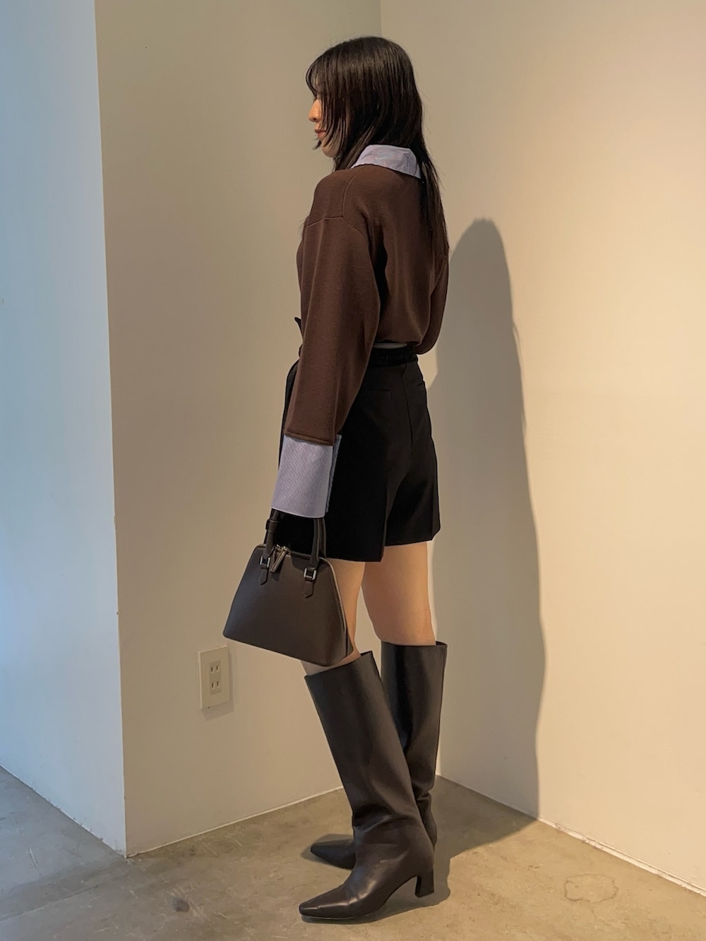 ブラウン系のニット/セーター、ブラウン系のブーツ、ブラック系のその他パンツを着用したレディースの秋コーディネートの2枚目の写真