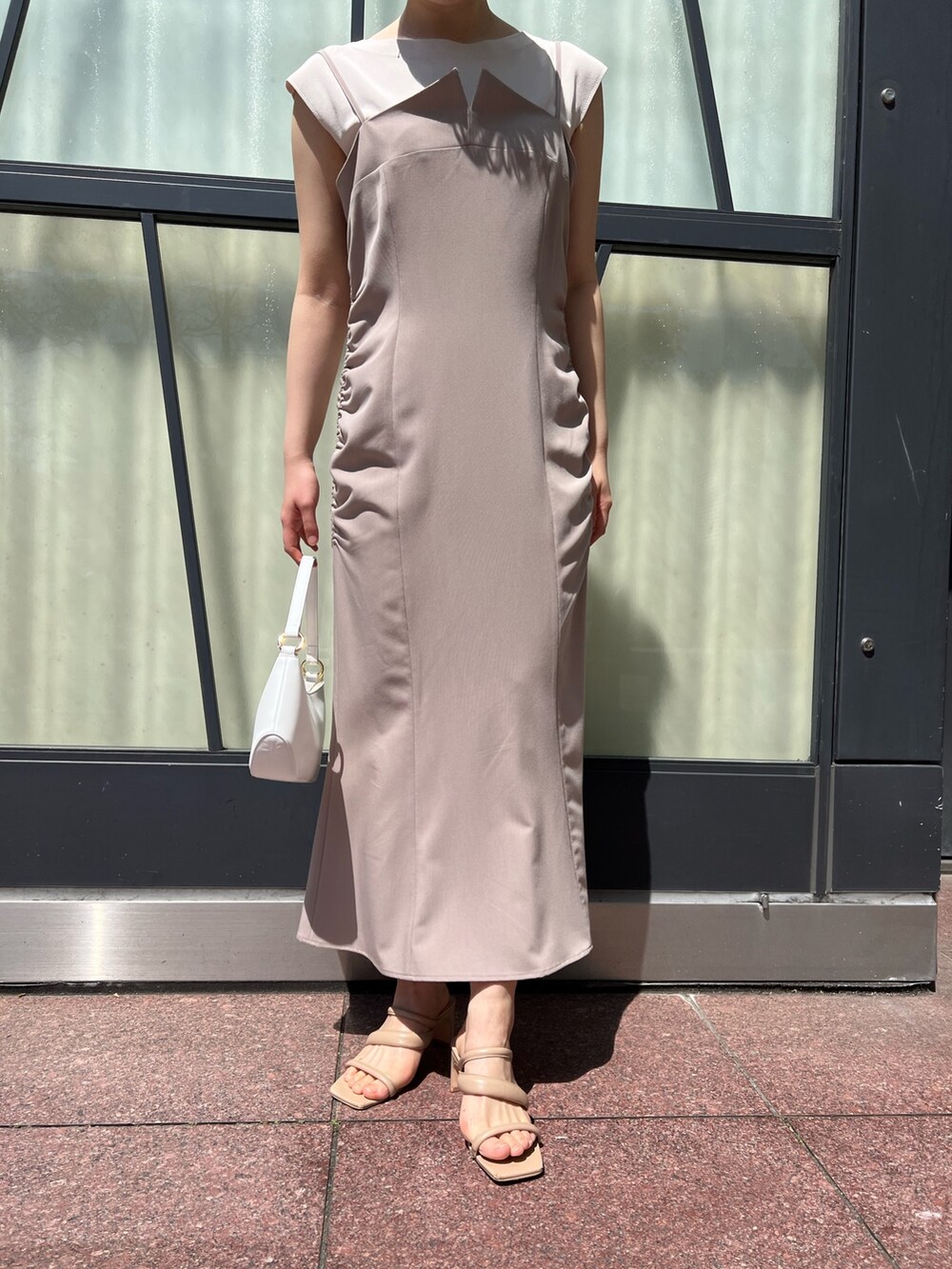 ベージュ系のワンピース、ピンク系のテーラードジャケット、ホワイト系のハンドバッグを着用したレディースの春コーディネートの7枚目の写真