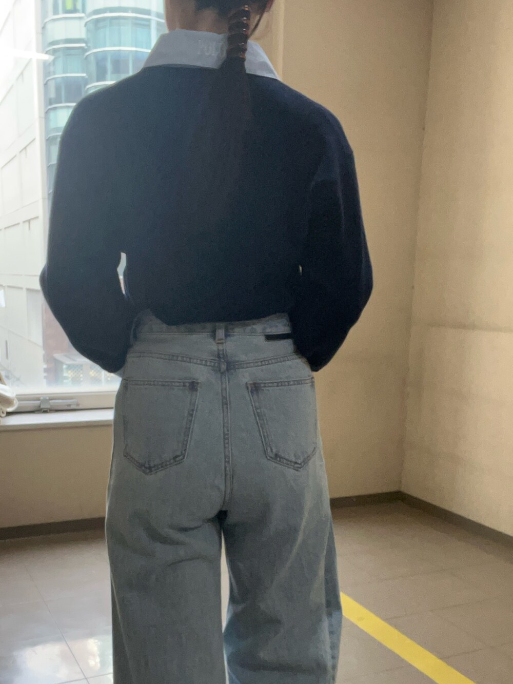 ブルー系のニット/セーター、ブルー系のデニムパンツを着用したレディースの冬コーディネートの6枚目の写真