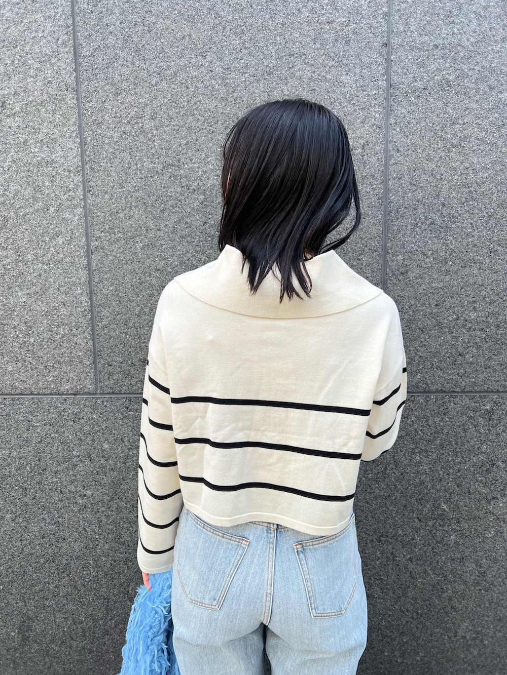 ブルー系のデニムパンツ、ホワイト系のニット/セーターを着用したレディースの冬コーディネートの6枚目の写真