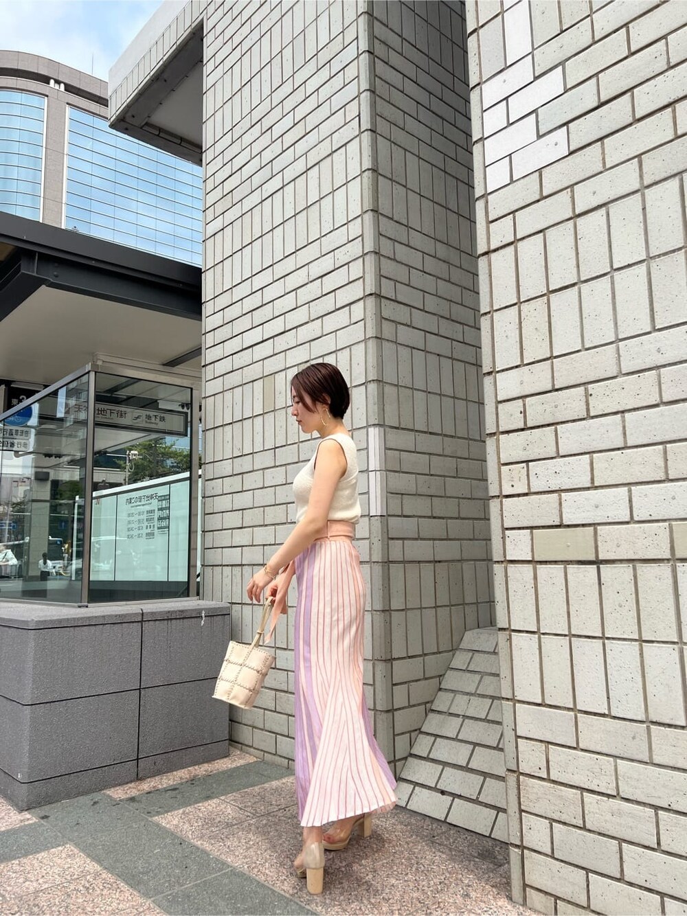 オレンジ系のスカート、その他のパンプス、ホワイト系のショルダーバッグを着用したレディースの春コーディネートの8枚目の写真