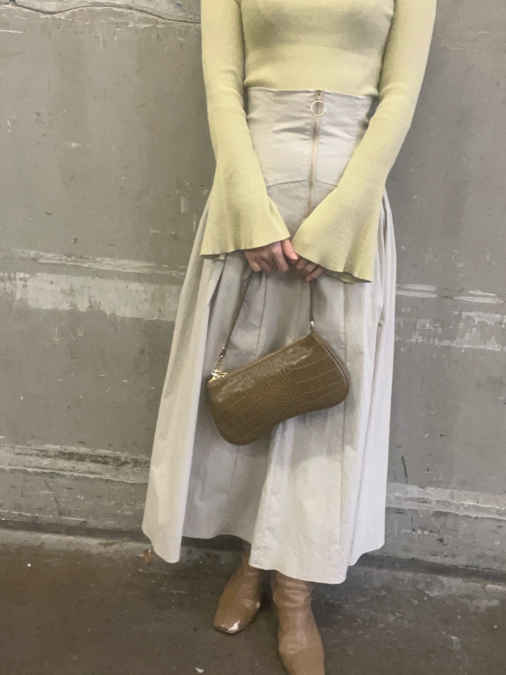 ベージュ系のブーツ、ホワイト系のスカート、グリーン系のニット/セーターを着用したレディースの冬コーディネートの8枚目の写真